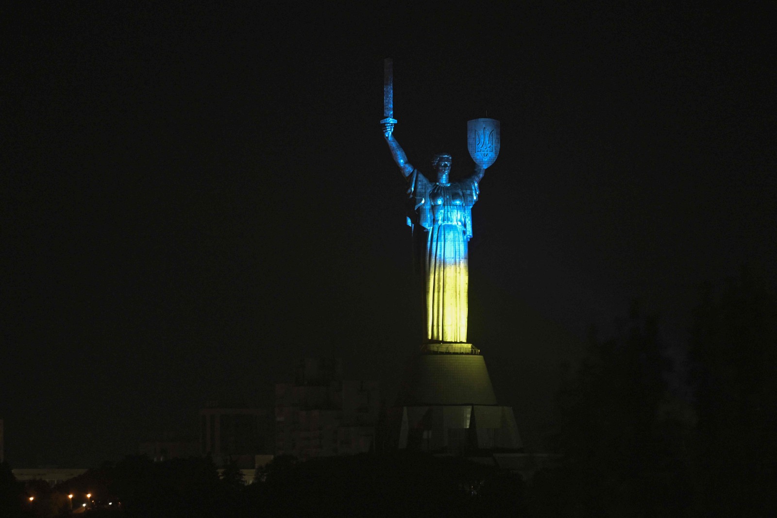 O monumento da Pátria iluminado com as cores da bandeira nacional ucraniana durante o Dia da Bandeira do Estado da Ucrânia, antes do Dia da Independência da Ucrânia, em meio à invasão russa — Foto: Genya SAVILOV / AFP