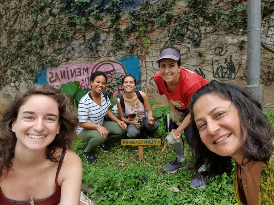 Vem, grafite! Renata (à direita) com voluntárias diante da horta e do muro