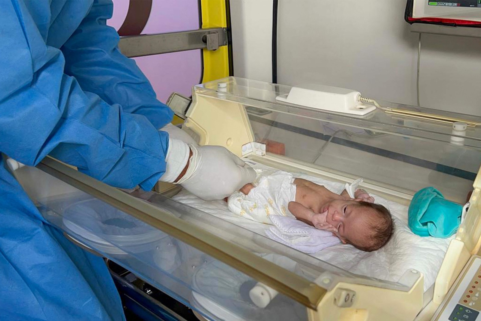 Bebê palestino é elevado por médicos egípcios em ambulância após ataque a hospital — Foto: AFP