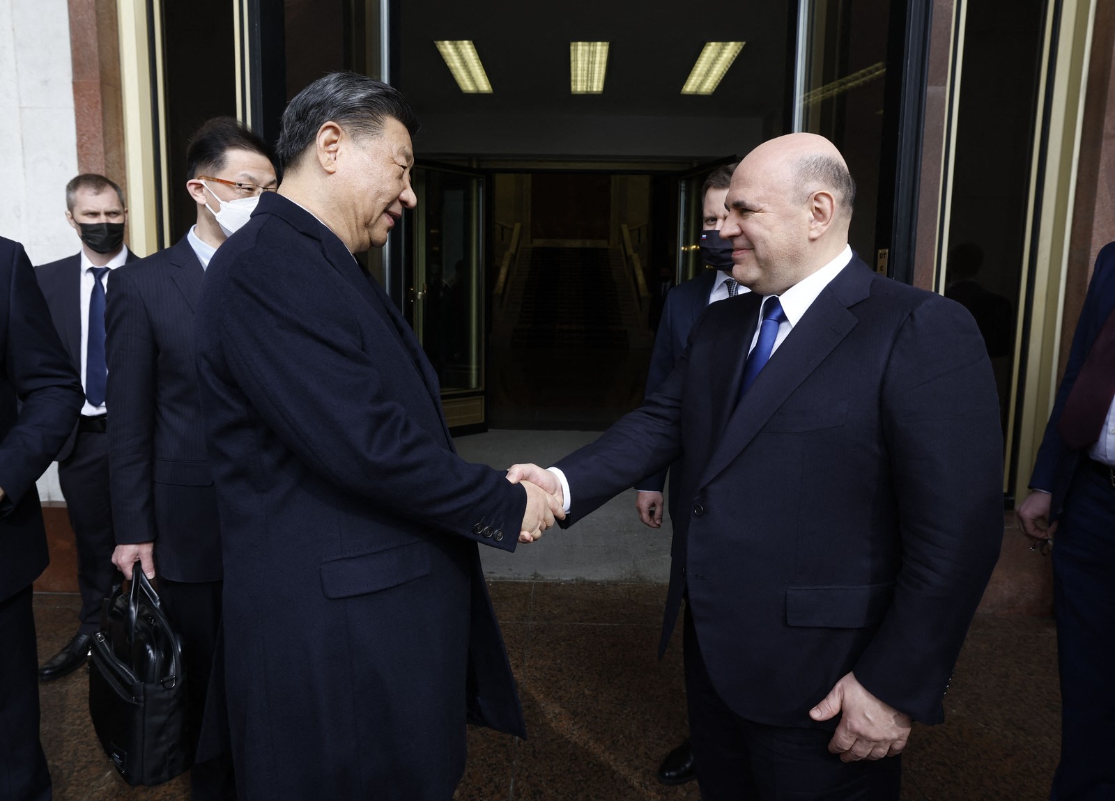 O presidente chinês, Xi Jinping, cumprimenta o premier russo, Mikhail Mishustin, em Moscou — Foto: DMITRY ASTAKHOV/AFP