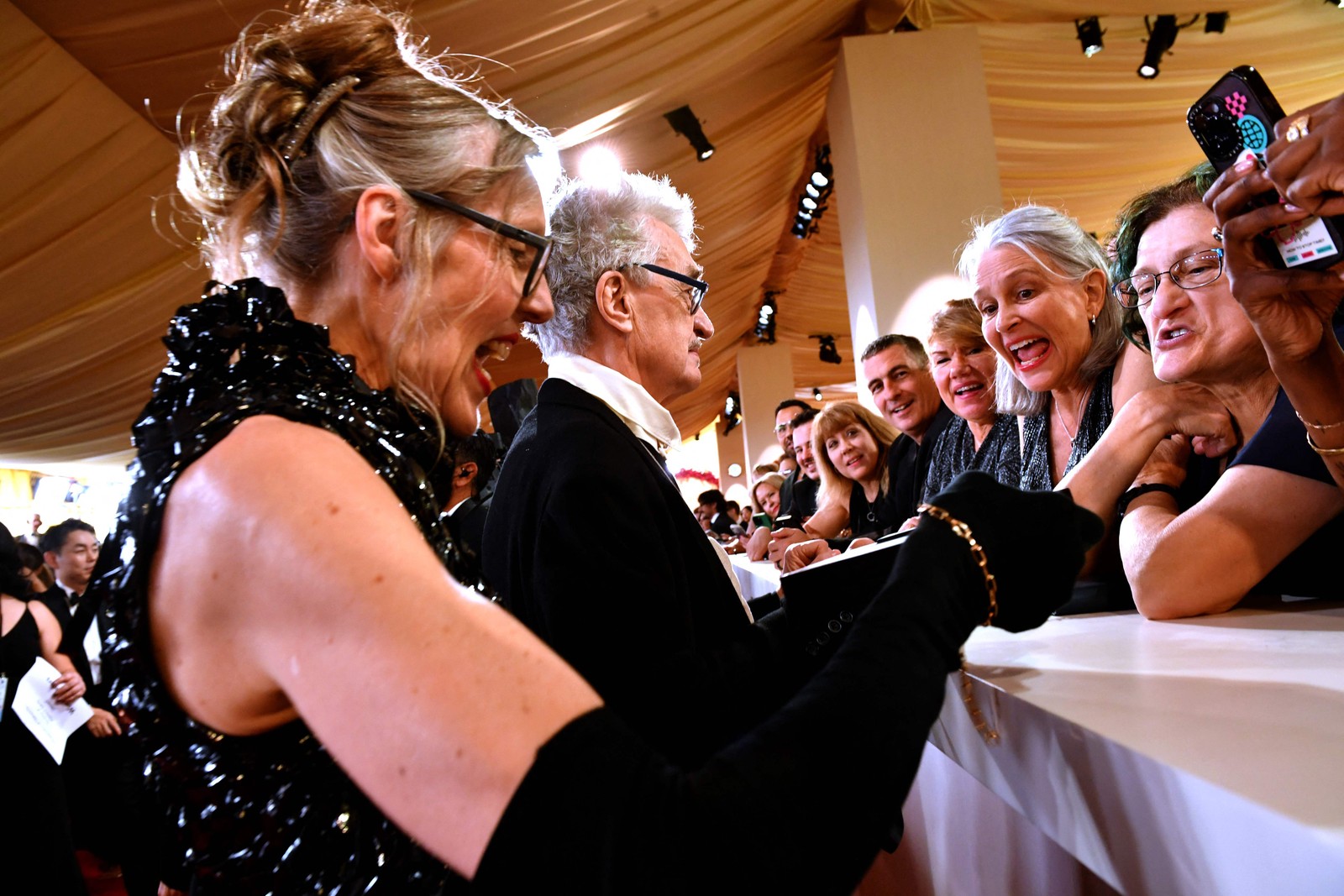 O diretor Wim Wenders e a mulher, a fotógrafa Donata Wenders, não deixaram de dar atenção para a turma que vai ver as estrelas — Foto: Valerie Macon / AFP