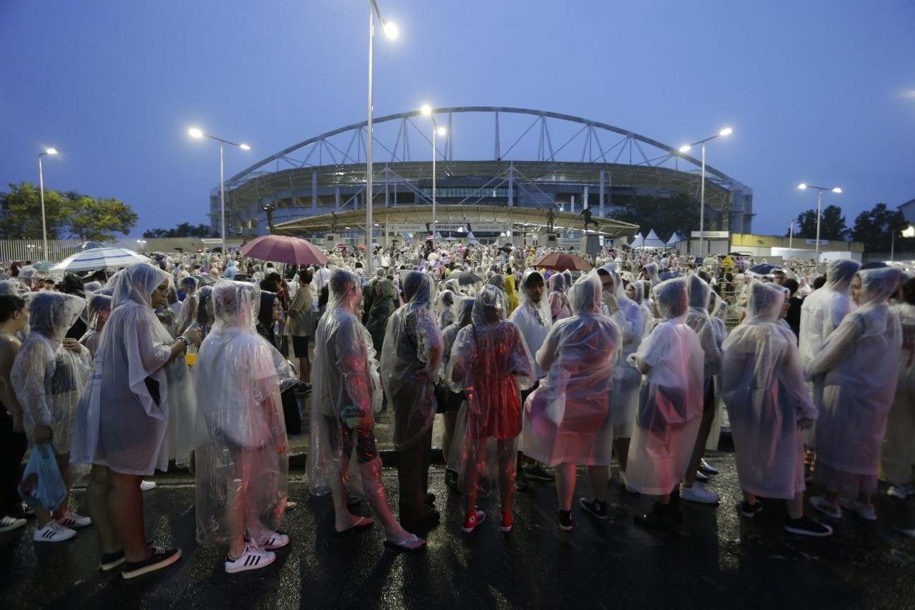 Sob chuva, fãs da cantora Taylor Swift aguardam para entrar no Estádio Nilton Santos — Foto: Domingos Peixoto / Agência O Globo