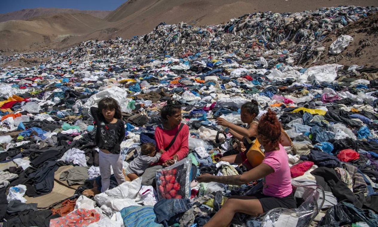 Mulheres 'garimpam' roupas em meio a toneladas descartadas no deserto do Atcama, no Chile Foto: MARTIN BERNETTI / AFP Vista aérea das toneladas de roupas descartadas nas colinas do deserto do Atacamo, na região de Alto Hospício Foto: MARTIN BERNETTI / AFP Vista aérea das toneladas de roupas descartadas nas colinas do deserto do Atacamo, na região de Alto Hospício  — Foto: MARTIN BERNETTI / AFP