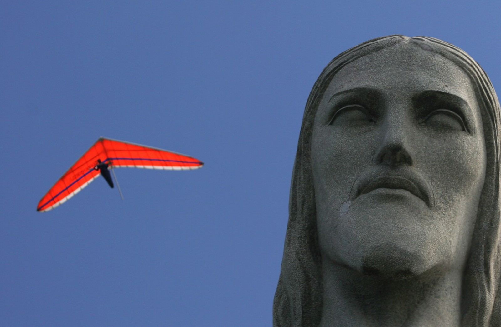 Asa delta passa ao lado do Cristo em dia de céu limpo após dias de chuva. Foto Márcia Foletto / Agência O Globo