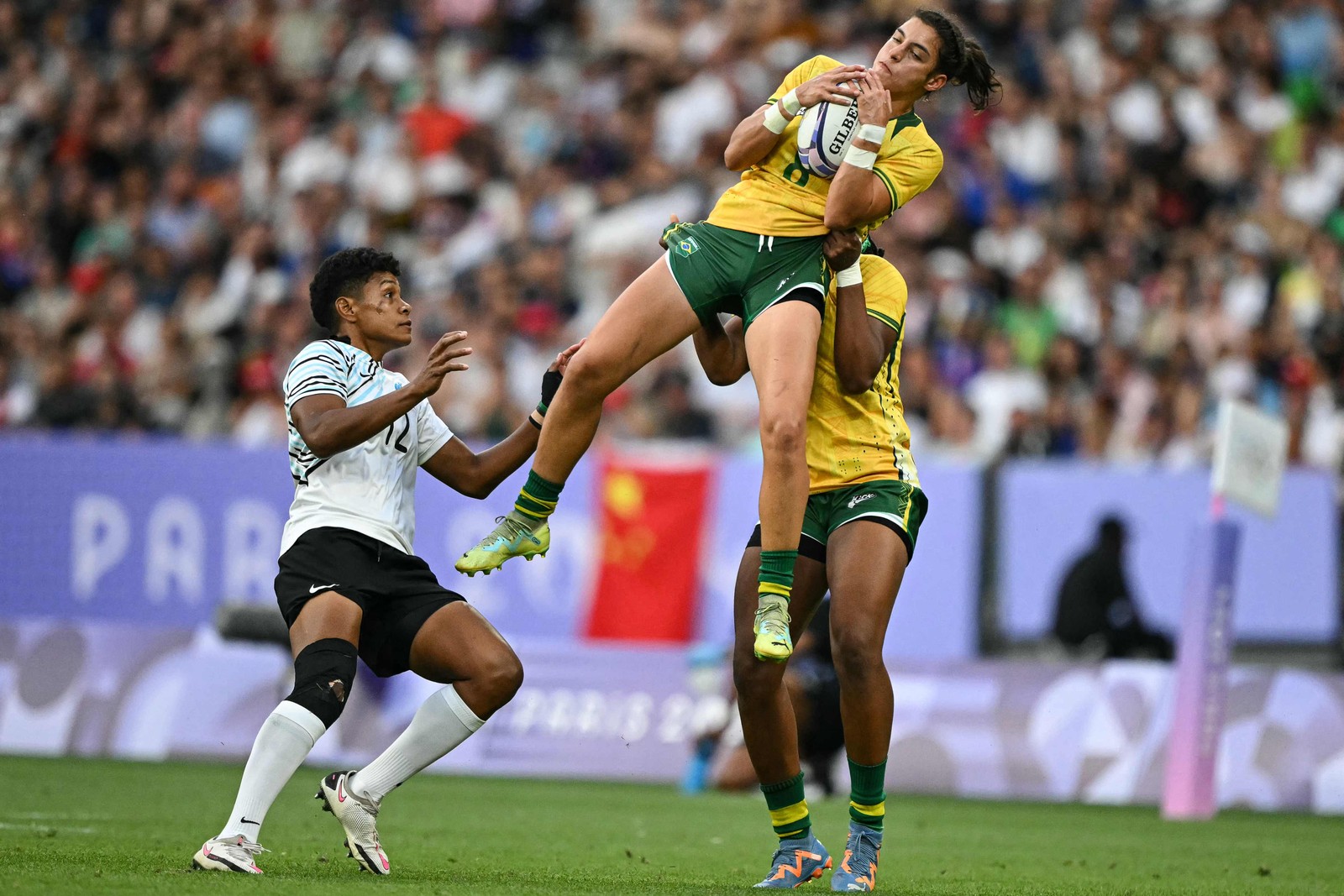 A brasileira Marina Fioravanti pega a bola e passa por Sesenieli Donu de Fiji durante a partida de rúgbi sevens feminino — Foto: CARL DE SOUZA / AFP