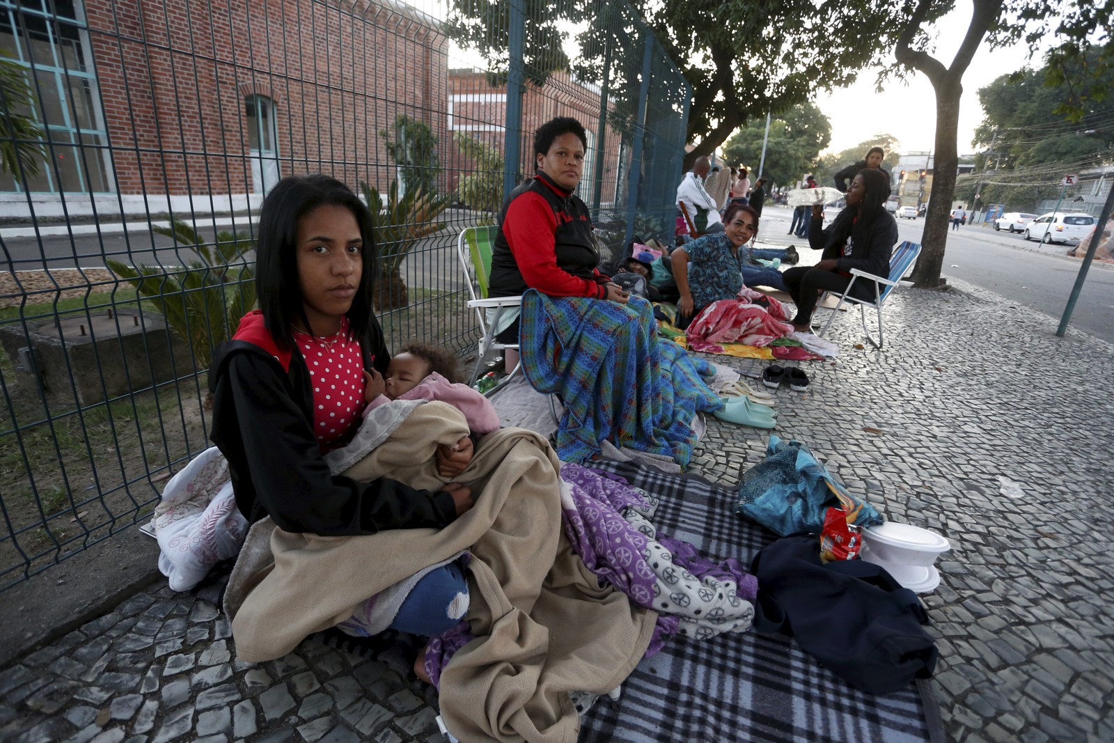 A fila se formou na noite anterior ao começo do atendimento. Muitos dormiram ao relento, incluindo crianças  — Foto: Fabiano Rocha / Agência O Globo