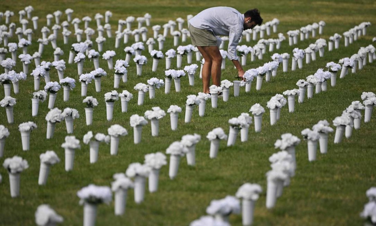 Pessoa deixa flores antes da abertura do Gun Violence Memorial no National Mall em Washington — Foto: MANDEL NGAN / AFP