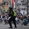 Policial joga bomba de gás lacrimogêneo contra manifestantes na Venezuela - Yuri CORTEZ / AFP