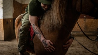 Soldado ucraniano abraça um cavalo durante uma sessão de terapia em um centro de reabilitação na Ucrânia — Foto: Nicole Tung/The New York Times