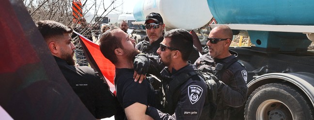 Ativistas da paz – palestinos e israelenses – protestam na entrada de Huwara, alvo de ataque extremista, na Cisjordânia ocupada — Foto: JAAFAR ASHTIYEH/AFP
