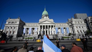 Apoiadores de Javier Milei aguardam a cerimônia de posse em frente ao prédio do Congresso — Foto: Luis ROBAYO / AFP