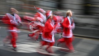 Corredores vestidos de papai noel participam da Santa Dash, evento anual de cinco quilômetros na cidade de Liverpool, Inglaterra — Foto: OLI SCARFF/AFP