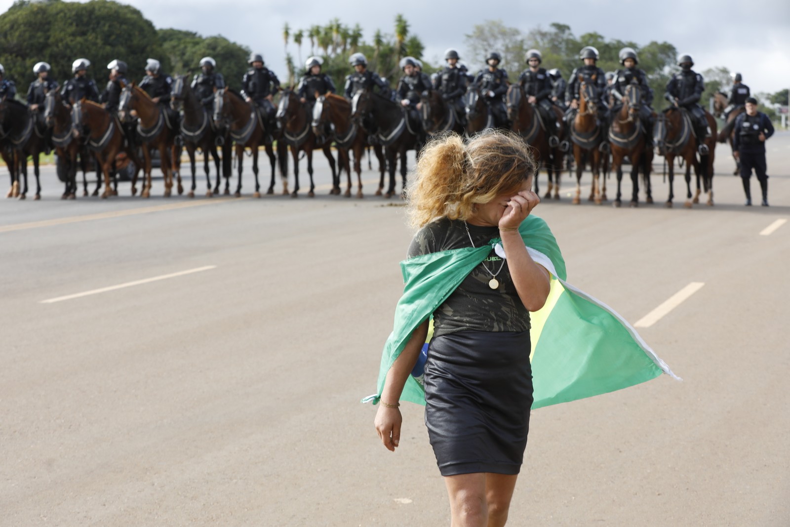 Manifestante bolsonarista chora enquanto policiais bloqueiam área do acampamento.  — Foto: Cristiano Mariz