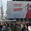 Ucranianos caminham diante de outdoor com propaganda de um cassino online em Kiev; jogos de azar foram proibidos para o Exército da Ucrânia após indícios de que soldados estão viciados - Sergei Supinsky/AFP