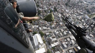 Helicóptero do Exército Brasileiro sobrevoa o Complexo do Chapadão jogando panfletos — Foto: Domingos Peixoto / Agência O Globo
