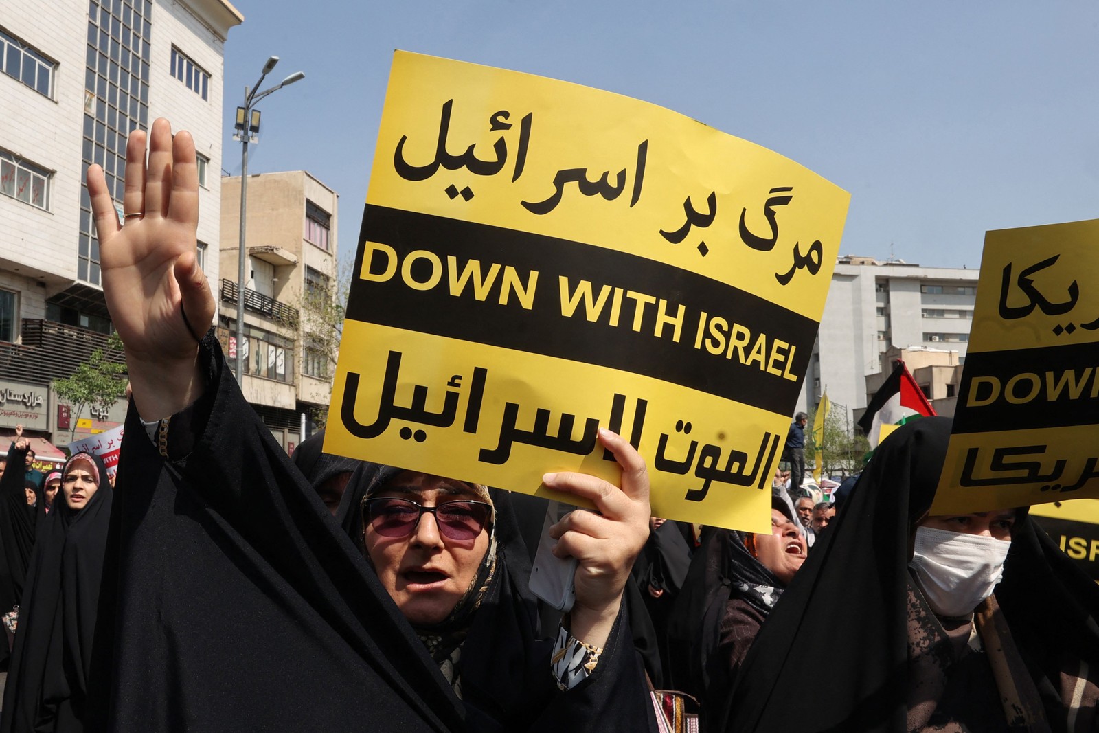 Iranianos carregam placas com o dizer "Abaixo Israel" durante manifestação em Teerã — Foto: Atta KENARE / AFP