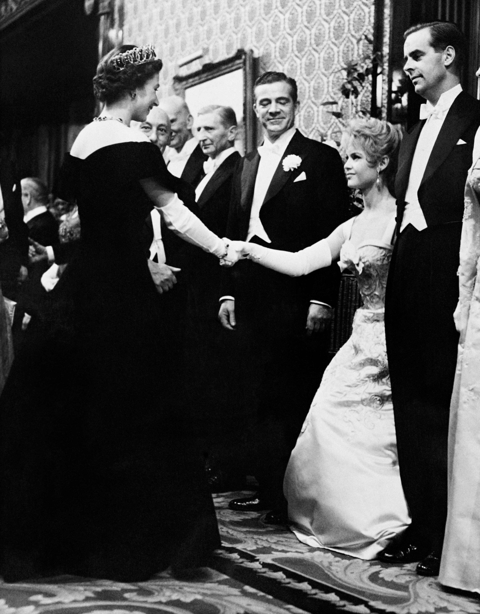 A atriz francesa Brigitte Bardot se curva à Rainha Elizabeth II durante a Apresentação do Comando Real, em Londres em outubro de 1956. — Foto: AFP