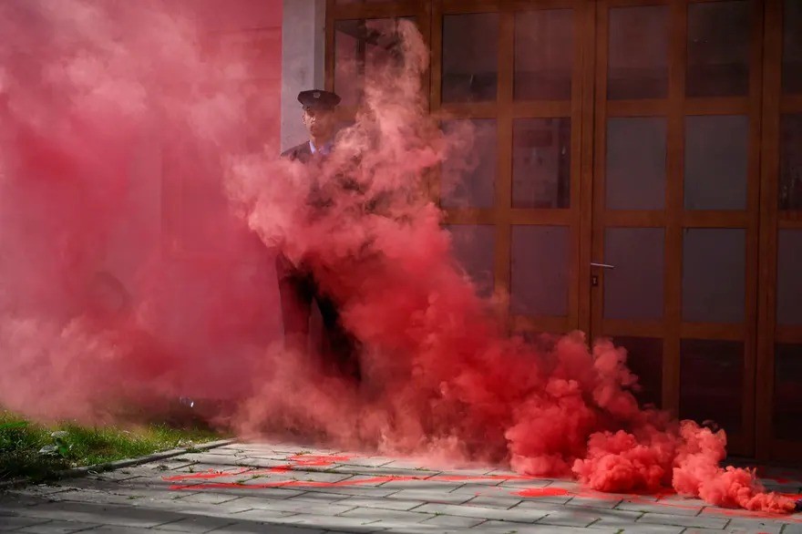 Um policial fica em meio à fumaça de um sinalizador durante uma manifestação em Pristina, Kosovo — Foto: Armend Nimani/AFP/Getty