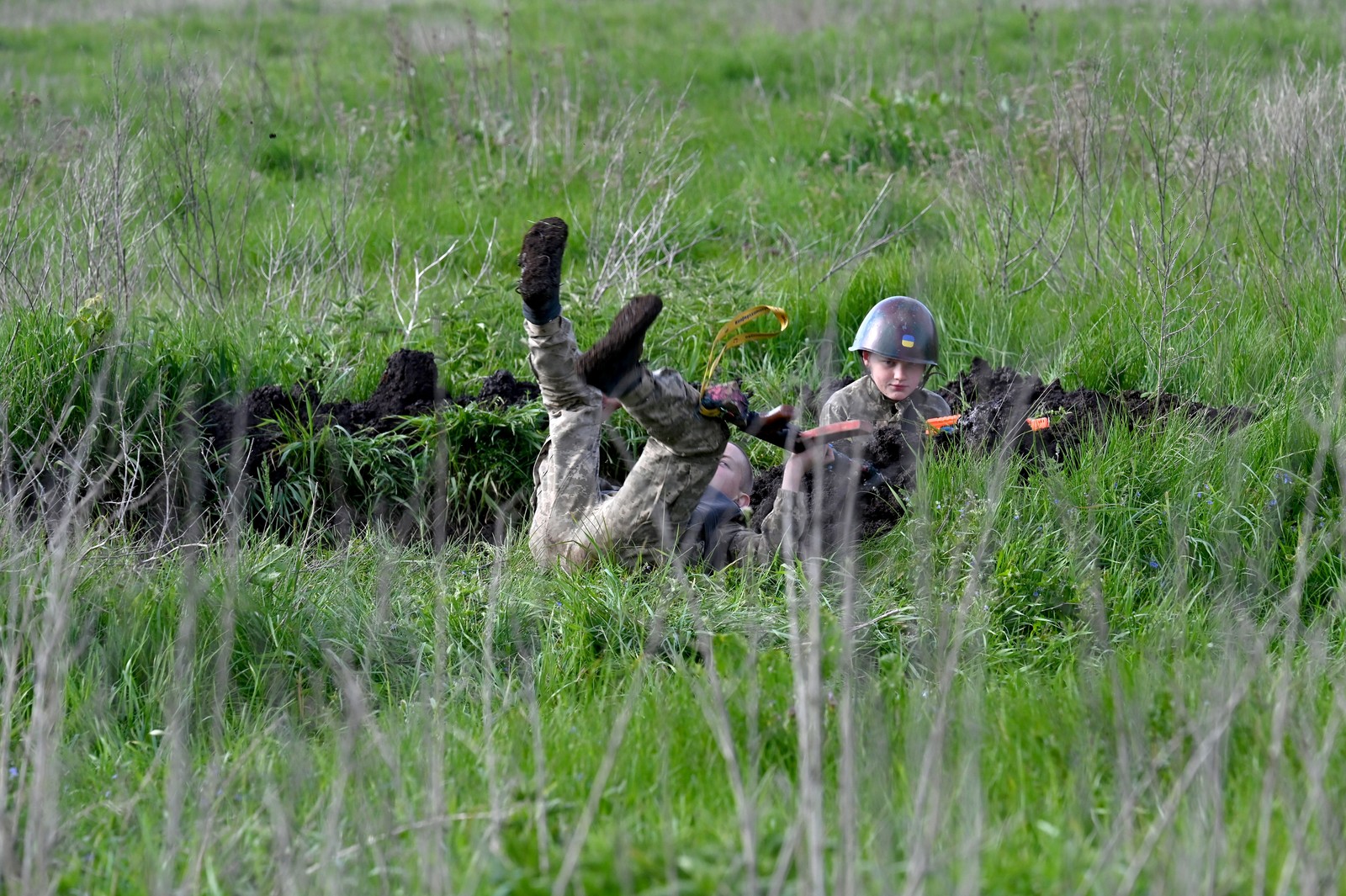 Andriy Shyrokyh, de 13 anos, e Maksym Mudrak, de 10 anos, vestindo uniformes de combate e coletes à prova de bala feitos em casa, nos arredores de Kiev — Foto: Sergei Supinsky/AFP