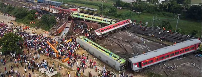 Equipes de resgate se reúnem em torno dos trens danificados no local da colisão perto de Balasore, a cerca de 200 km da capital do estado Bhubaneswar — Foto: Dibyangshu SARKAR / AFP