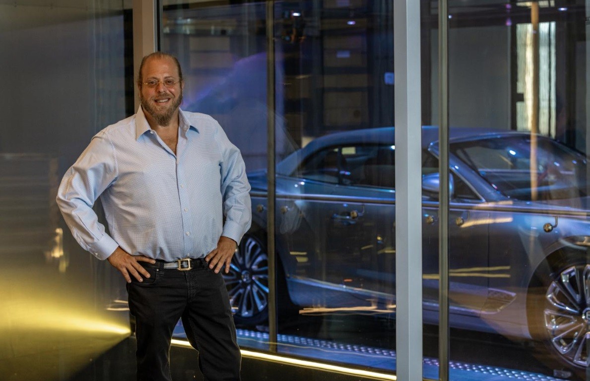 Gil Dezer, o empreendedor por trás do Porsche Design Tower e do Bentley Residences, posa em frente a um carro estacionado no “dezervator”, elevador que leva motorista e veículo até a residência, onde o veículo  pode ser visto da unidade através de uma parede de vidro — Foto: Scott Baker/The New York Times