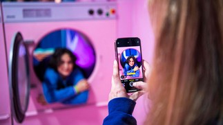 Pessoas visitam a "laundry room" e tiram fotos dentro das máquinas de lavar, no Youseum, em Solna, perto de EstocolmoAFP