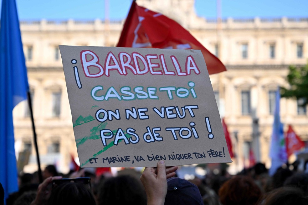 Um manifestante segura um cartaz que diz "Bardella: vá embora, não queremos você aqui" durante uma manifestação contra o partido francês de extrema direita "Rassemblement National" (RN) em Marselha, sul da França, em 10 de junho de 2024, um dia depois que o partido venceu as eleições europeias na França. — Foto: Nicolas TUCAT/AFP