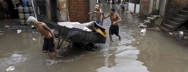 Moradores retiram móveis e objetos danificados com a chuva na comunidade Parmalat, em Acari. — Foto: Márcia Foletto