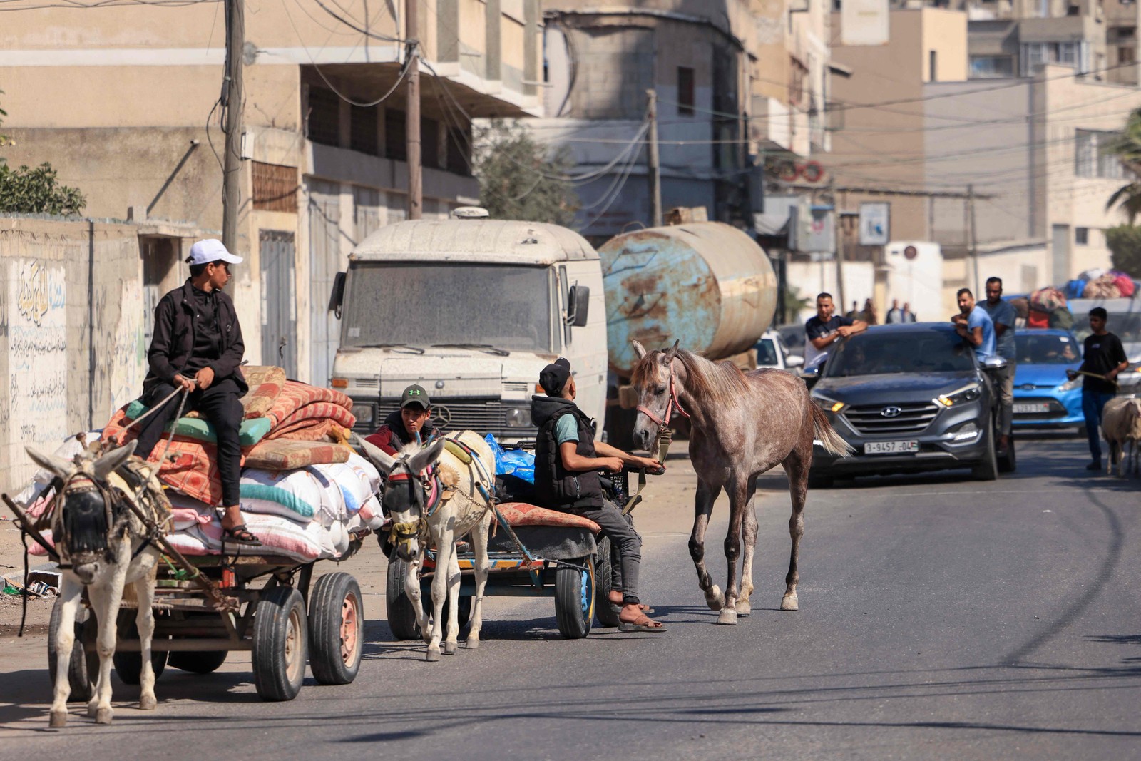 Palestinos com seus pertences fogem para áreas mais seguras na Cidade de Gaza após ataques aéreos israelenses — Foto: Mahmud Hams / AFP