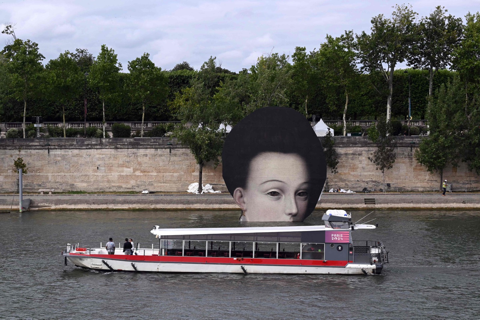 Barco navega pelo Sena diante de mural instalado para cerimônia de abertura de Paris-2024 — Foto: SEBASTIEN BOZON / AFP