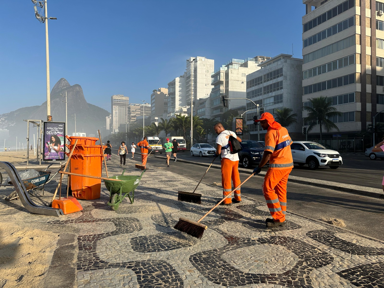 Garis fazem a limpeza na orla do Leblon — Foto: Márcia Foletto/Agência O Globo