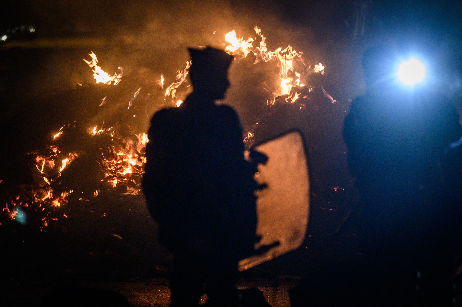 Policiais franceses protegem área após dispersão de protestos no acesso ao terminal de petróleo, no oeste da França — Foto: LOIC VENANCE/AFP