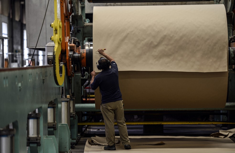 Funcionário manipula rolo de papel reciclado em fábrica da Klabin: empresa foi fundada em 1899 — Foto: Paulo Fridman/Bloomberg