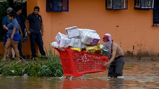 Um saqueador carrega um carrinho de compras cheio de mercadorias roubadas de um supermercado após a passagem do furacão Otis em Acapulco, estado de Guerrero, México — Foto: FRANCISCO ROBLES/AFP