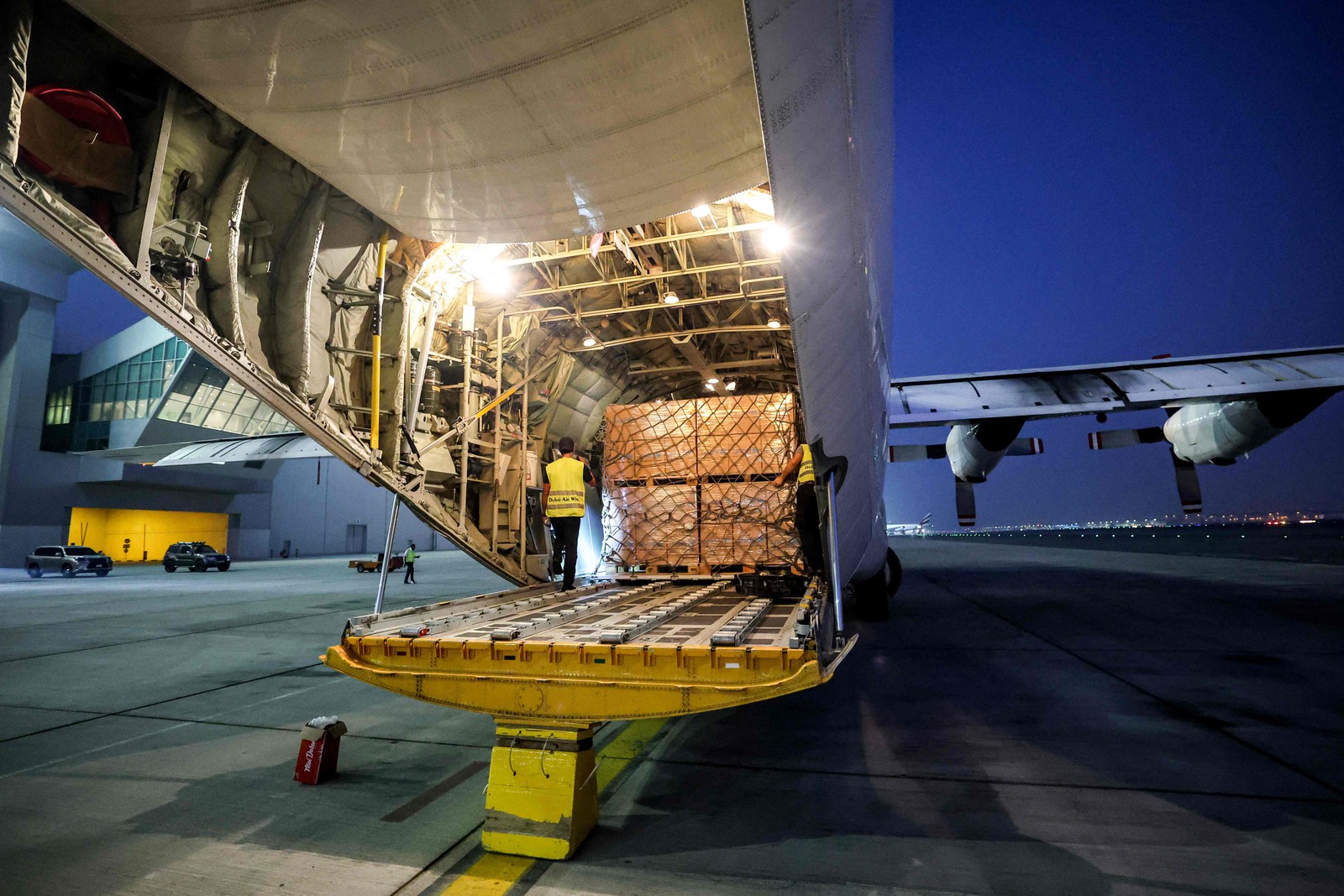 Pacotes com ajuda humanitária cedidos pela ONU para Gaza são colocados em avião no aeroporto de Dubai — Foto: Giuseppe CACACE / AFP