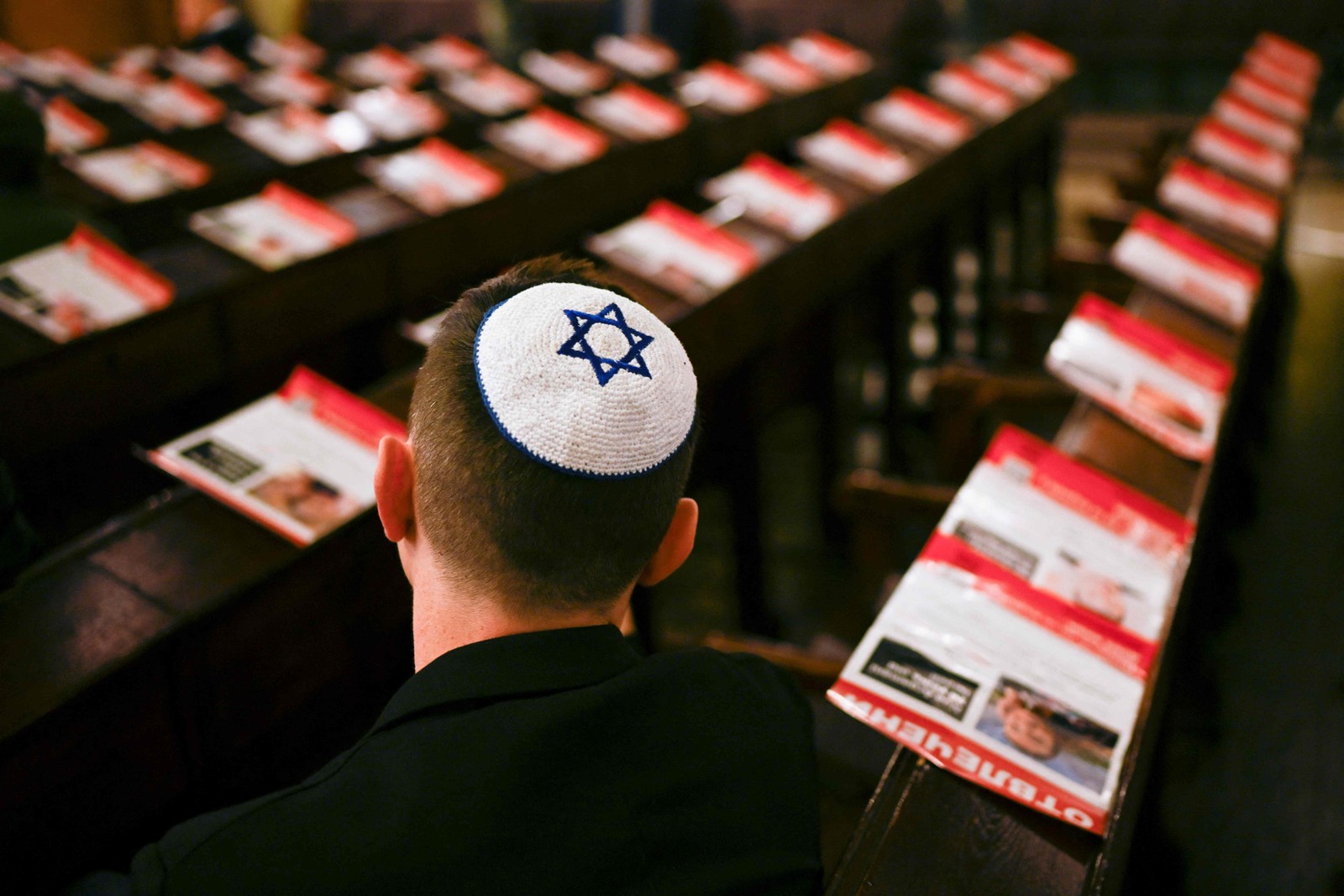 Membro da comunidade judaica búlgara, cercado por retratos de israelenses mantidos reféns pelo Hamas, participa de uma cerimônia memorial na Sinagoga de Sofia, em Sófia, em 6 de novembro de 2023 — Foto: Nikolay DOYCHINOV / AFP