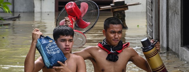 Moradores evacuam suas casas após o Super Tufão Noru, em San Ildefonso, província de Bulacan, nas Filipinas — Foto: Ted ALJIBE / AFP