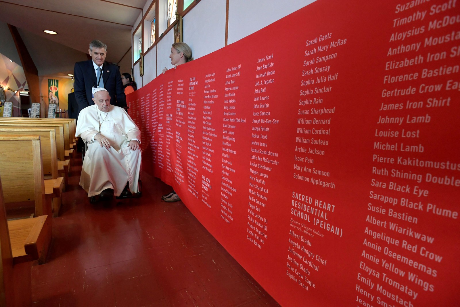 Papa Francisco observa uma faixa com nomes de vítimas de abusos cometidos em escolas residenciais administradas pela Igreja Católica, na Igreja Nossa Senhora das Sete Dores), em Maskwacis, ao sul de Edmonton, oeste do Canadá. — Foto: Vaticano / AFP