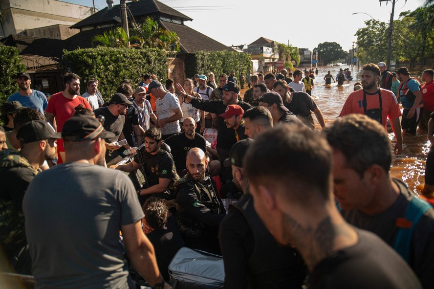 Pessoas participam de operações de resgate em Porto Alegre:  chuvas diminuíram, mas inundações permanecem