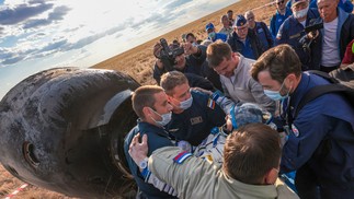 O cosmonauta russo Sergey Prokopyev é ajudado por especialistas após seu pouso na cápsula Soyuz MS-23 — Foto: AFP