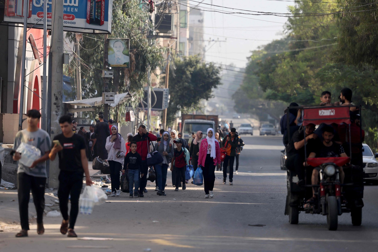 Palestinos carregando seus pertences fogem para áreas mais seguras na Cidade de Gaza — Foto: AFP