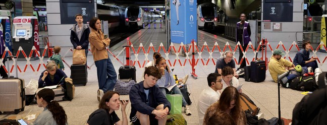 Com sistema de trens rápidos afetados na França, passageiros sentam no chão da estação Montparnasse à espera de uma solução; problemas devem durar até o fim de semana — Foto: Thibaud Moritz / AFP