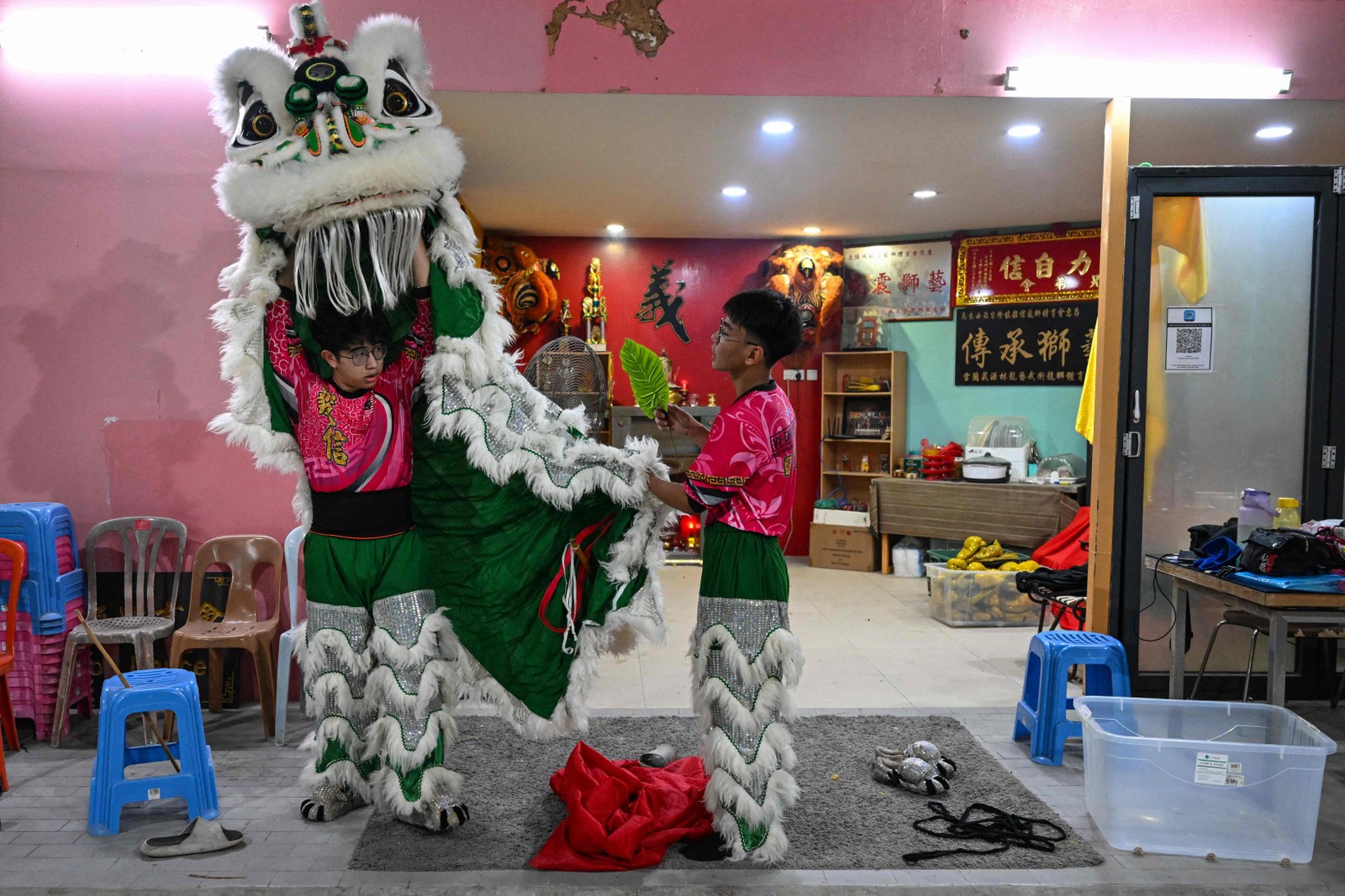 Membros de uma trupe de dança do leão provam traje antes de um ensaio para as celebrações do Ano Novo Lunar do Coelho, em Kuala Lumpur.  — Foto: Mohd RASFAN / AFP