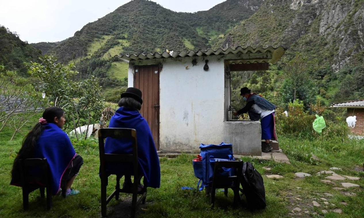 Enfermeira indígena da etnia Misak Anselmo Tunubala, 49, lava as mãos antes de preparar uma dose da vacina Sinovac contra COVID-19 para imunizar uma idosa indígena, na reserva indígena Guambia, zona rural de Silvia, departamento de Cauca, Colômbia — Foto: LUIS ROBAYO / AFP