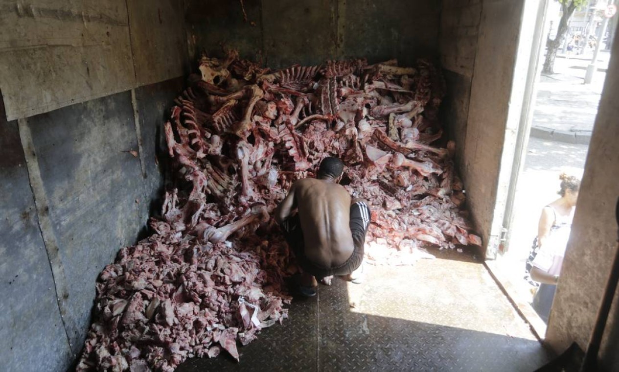 Luis Vander, 39 anos, escolhe suas peças e ajuda a organizar a distribuição. Em situação de rua, ele tem habitado as calçadas da Glória. — Foto: Domingos Peixoto / Agência O Globo