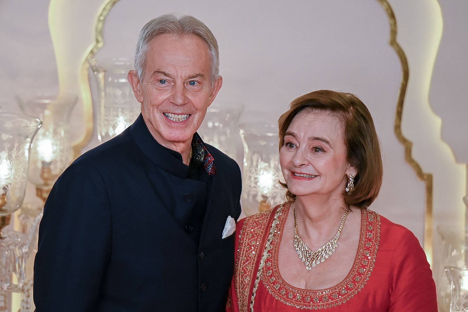 Ex-premier britânico, Tony Blair chega para megacasamento na Índia com a mulher, Cherie Blair — Foto: Punit PARANJPE / AFP