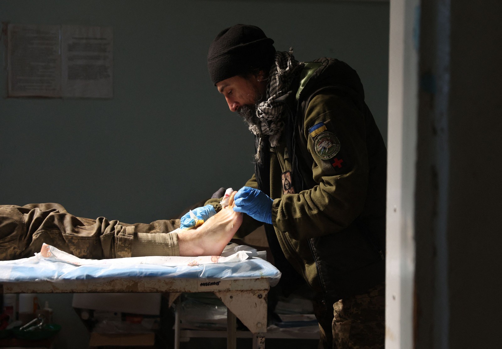 Médico militar faz um curativo em um soldado ucraniano ferido em um hospital na região de Donetsk. — Foto: Anatolii Stepanov / AFP