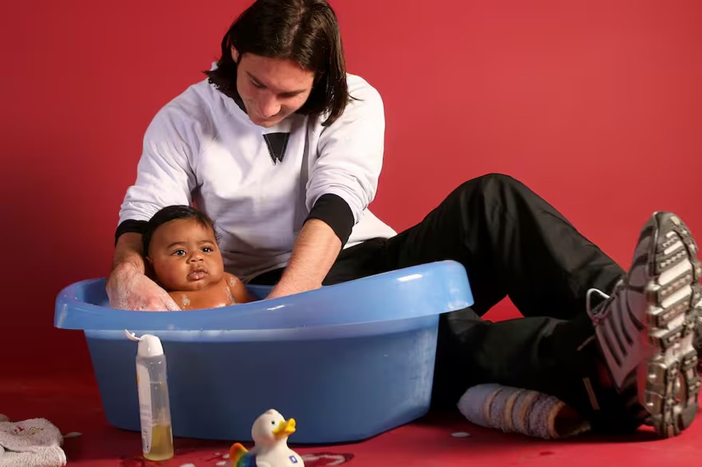 Lionel Messi banha o pequeno Lamine Yamal de apenas cinco meses para uma campanha solidária em 2007 — Foto: Reprodução