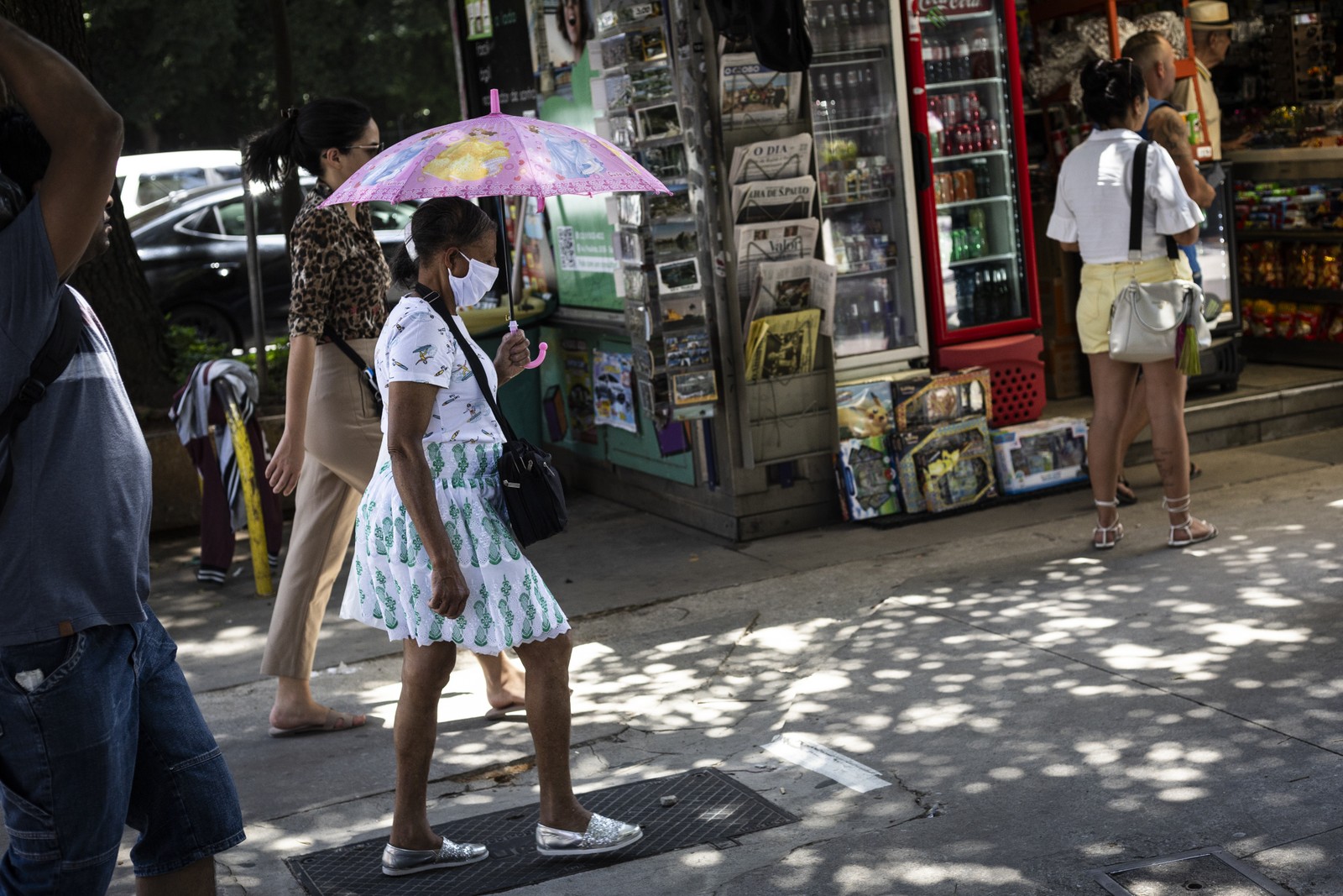 Pessoas andam com guarda-chuva para se proteger do Sol durante onda de calor — Foto: Maria Isabel Oliveira/Agência O Globo