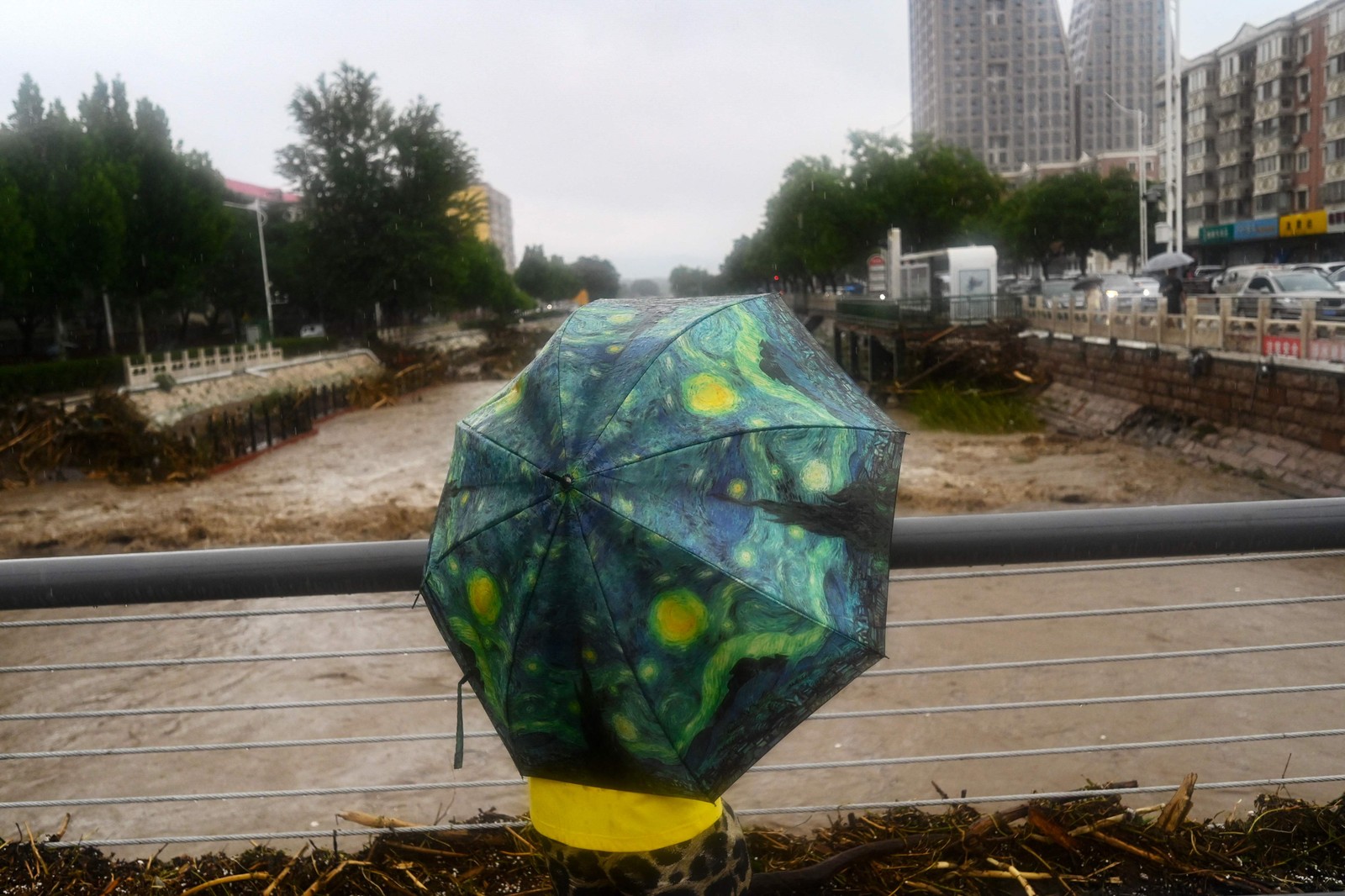 Uma pessoa observa o rio Yongding, inundado, após fortes chuvas no distrito de Mentougou, em Pequim, em 31 de julho de 2023 — Foto: Pedro PARDO / AFP